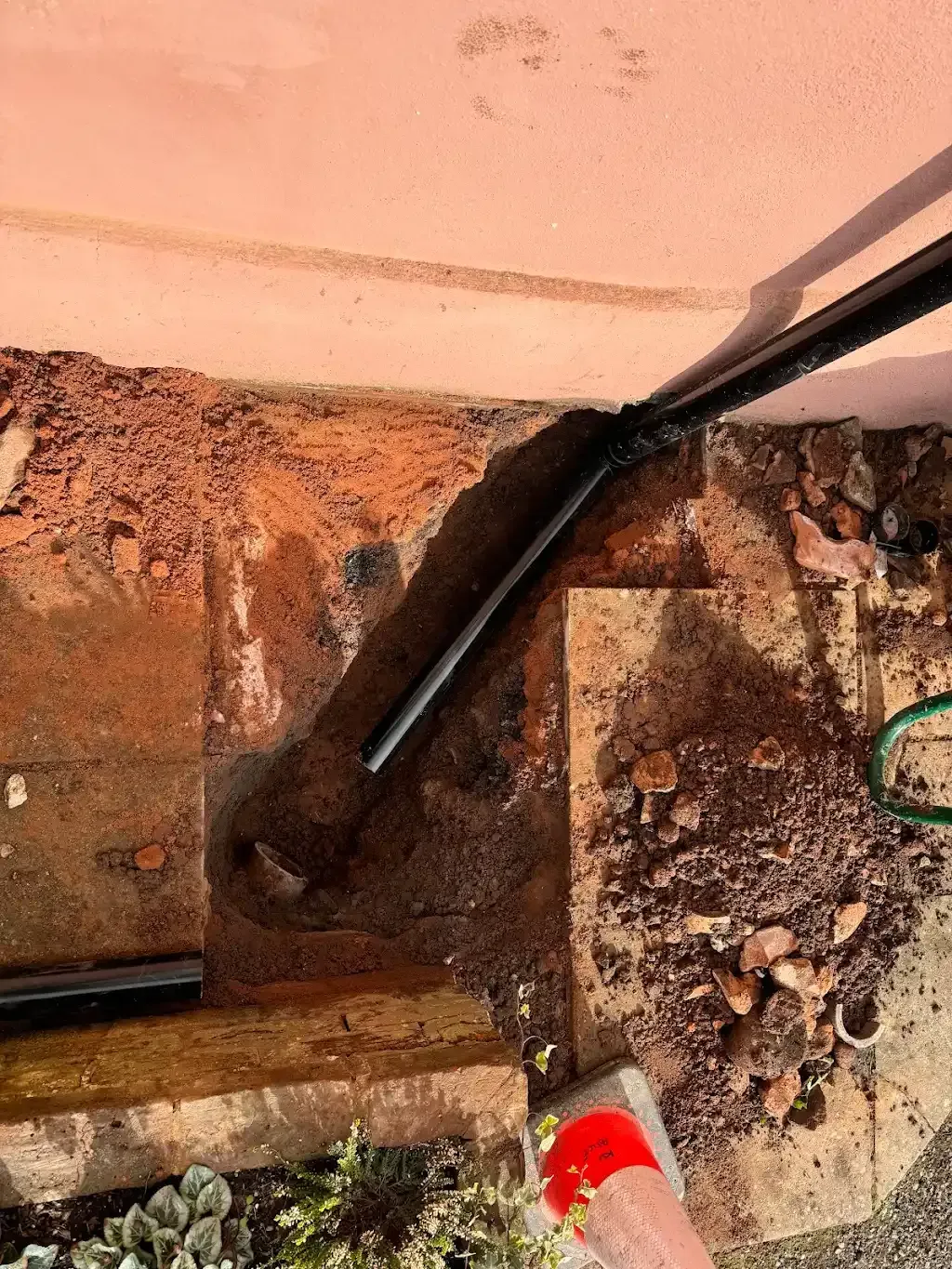 Drainage pipe installation next to a foundation wall in Devon
