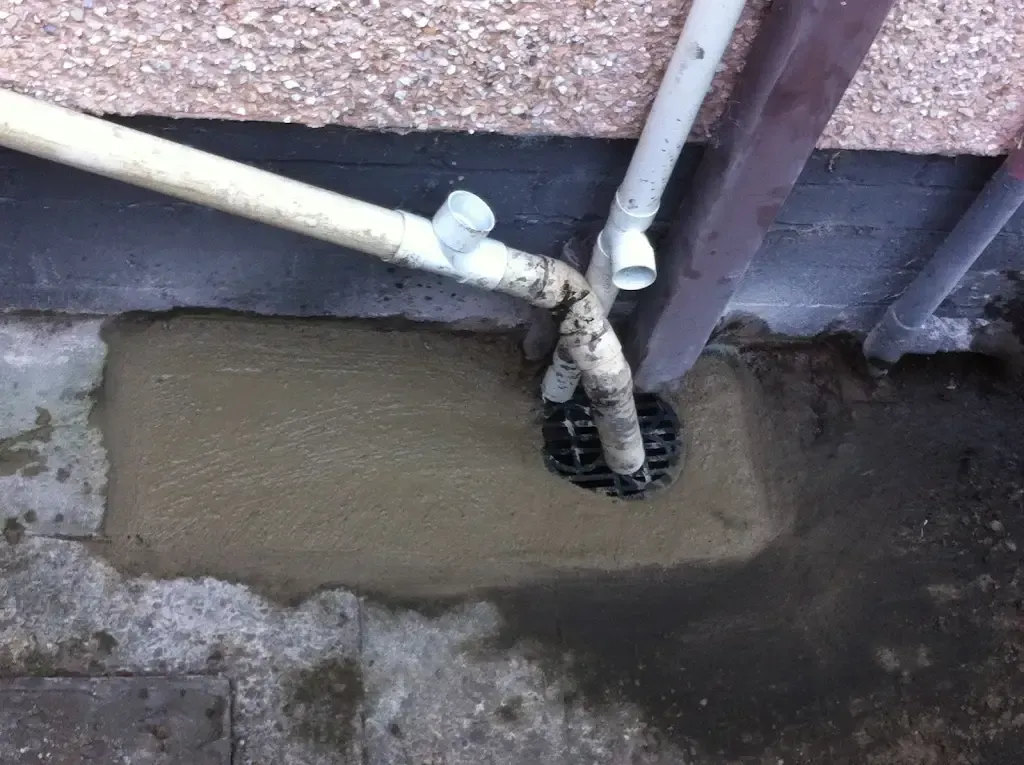 Outdoor drain with pipes and fresh concrete reinstatement